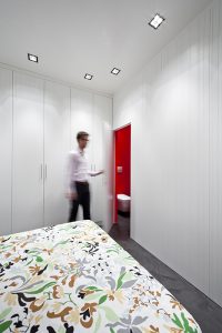 Ristrutturazione di piccolo appartamento nel cuore di Milano, tutto è realizzato con un unico arredo su misura che permette di sfruttare al meglio i piccoli spazi, trasformazione e trasformabilità le parole d'ordine, bianco e rosso, cucina a vista, interior design