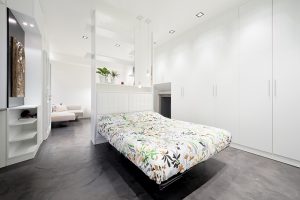 Ristrutturazione di piccolo appartamento nel cuore di Milano, tutto è realizzato con un unico arredo su misura che permette di sfruttare al meglio i piccoli spazi, trasformazione e trasformabilità le parole d'ordine, bianco e rosso, cucina a vista, interior design