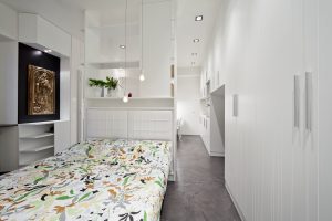 Ristrutturazione di piccolo appartamento nel cuore di Milano, tutto è realizzato con un unico arredo su misura che permette di sfruttare al meglio i piccoli spazi, trasformazione e trasformabilità le parole d'ordine, bianco e rosso, cucina a vista, interior design